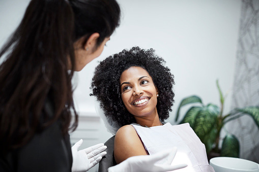 Woman talking to dentist during dental exam at  Riverwind Dental  in Richmond, VA 