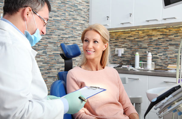 Woman talking to dentist during dental exam at Riverwind Dental in Richmond, VA
