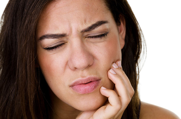 Woman holding jaw due to TMJ pain which can be remedied at Riverwind Dental in Richmond, VA